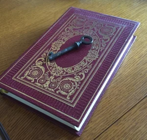 Un livre avec une clé posée sur la couverture, illustrant la lecture des archives akashiques.
